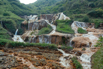 Fototapeta na wymiar Golden Waterfall And Lush Mountain View in Taiwan