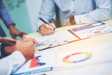 Businessman puts signature on contract at business meeting after negotiations with business partners. Selected focus