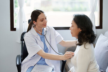 Portrait of a female doctor using a stethoscope to check the pulse of an elderly patient.