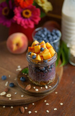 Breakfast yogurt granola parfait with peach and blueberry in a jar, healthy food, clean eating concept