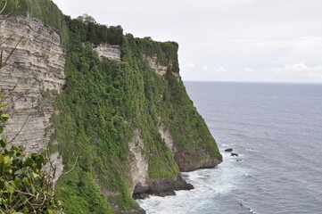 Fototapeta na wymiar Uluwatu beach in Bali with high cliffs next to it