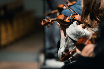 Musicians playing the viola or violin in a string section of a symphony orchestra