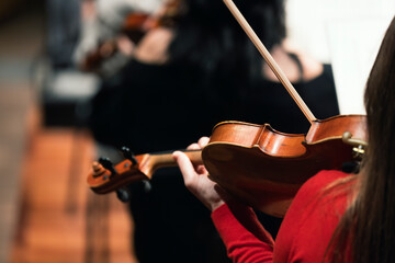 A musician playing the viola or violin in a string section of a symphony orchestra