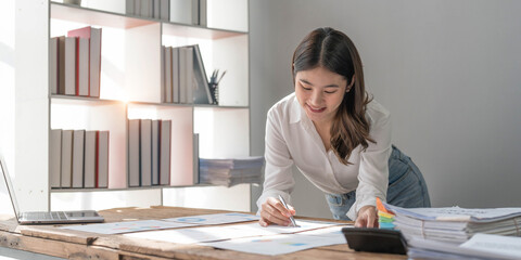 Business woman using calculator for do math finance on wooden desk in office and business working background, tax, accounting, statistics and analytic research concept..