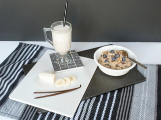 Oatmeal with Blueberries and Vanilla Banana Smoothie on White with Black Background