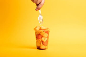 Vaso desechable de fruta con chile en polvo