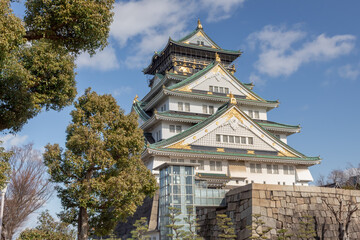 Naklejka premium Green and white traditional Japanese architecture building of the Osaka Castle in Osaka Japan