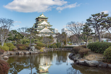 Obraz premium Green and white traditional Japanese architecture building and garden park and trees of the Osaka Castle in Osaka Japan