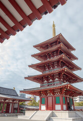 Fototapeta na wymiar Red and gold colorful temple traditional architecture building and pagoda at the Shi-Tennoji Buddhist Temple in Osaka Japan