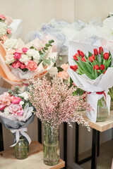 Flower shop concept. Different varieties fresh spring flowers in refrigerator room for flowers. Bouquets on shelf, florist business