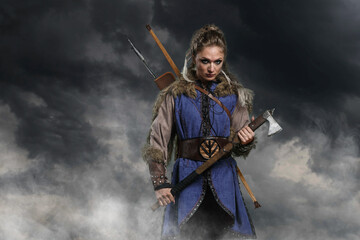 Beautiful female viking woman warrior in battle with ax and bow with arrows. Amazon fantasy blonde - 573419435