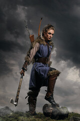 Beautiful female viking woman warrior in battle with ax and bow with arrows. Amazon fantasy blonde - 573419601