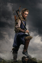 Beautiful female viking woman warrior in battle with ax and bow with arrows. Amazon fantasy blonde - 573419678