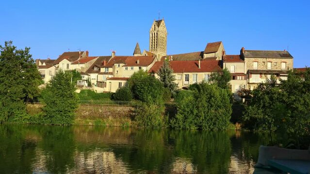 Marne river, residential buildings and local church along riverside in Dormans. Marne department, Grand Est region of France.