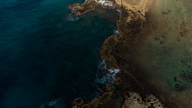 Abstract natural background with turquoise sea and rocks aerial view. © Evgeniia Freeman