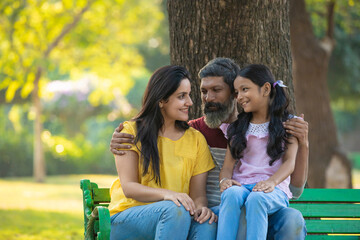 Fototapeta na wymiar Happy indian couple with his little girl at garden.