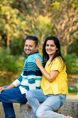 Fototapeta premium Young Indian couple sitting at park.