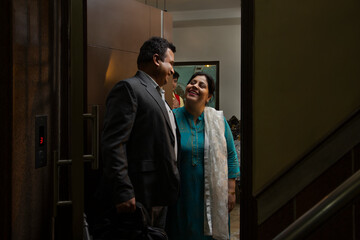 Woman saying goodbye to her husband at the door while going to office