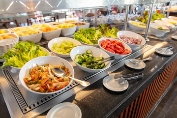 Vegetables with greens in plates on display in the dining room.