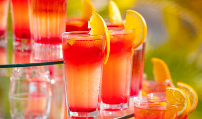 Red juicy cocktail with orange in cafe.