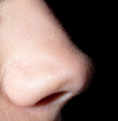 Girl's nose on a black background.