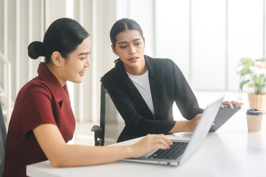 Two Business Asian Woman Using Laptop Computer In Office