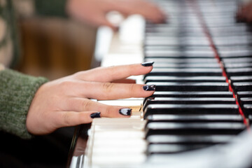 Girl's hands on the piano keys.