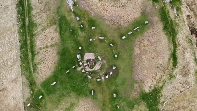 Rotating, birds-eye-view drone shot of the Callanish Standing Stones. Filmed on the Isle of Lewis, part of the Outer Hebrides of Scotland.