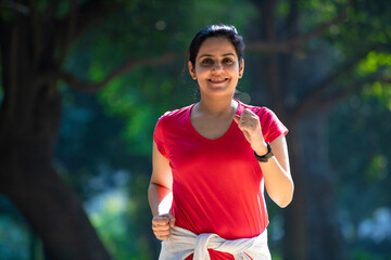 young indian woman jogging at park.