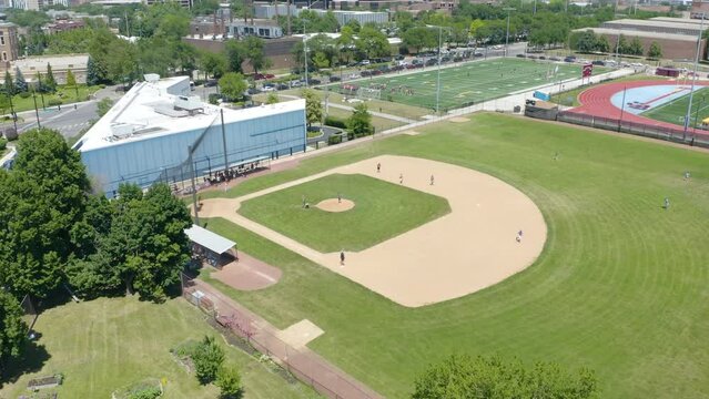 People Playing Baseball on Field in City during Summer - Cinematic Establishing Shot