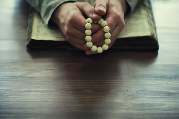 Reading religious literature. A man studies the Koran and sorts out the rosary.