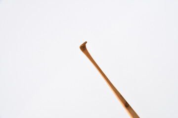 Handmade bamboo ear wax remover on white background.