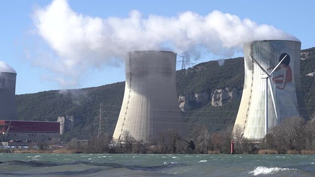 Cruas Nuclear Power Station, Wind Turbines, And Hyperboloid Cooling Tower With Mural Across The Rhone River. - pan left