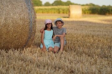 Naklejka na ściany i meble Beauty Couple relaxing on wheat field together. Teenage girlfriend and boyfriend having fun outdoors, kissing and hugging, first love concept. Teenagers Boy and Girl in love together