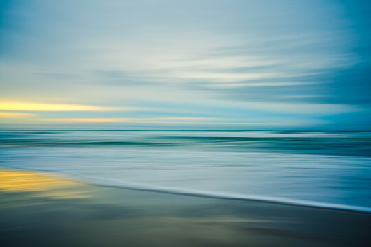 Sunset on the beach, abstract. Motion blur abstract seascape in light turquoise and yellow colors