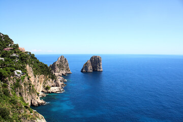 Fototapeta premium Top view on famous Faraglioni Rocks, Capri Island, Italy. Aerial view of landscape with azure sea, Capri island coastline and Faraglioni cliffs