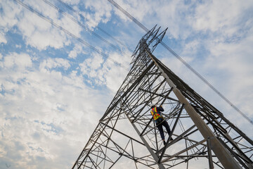 Asian electrical engineer wearing safety gear working high voltage pylon Engineering work on...