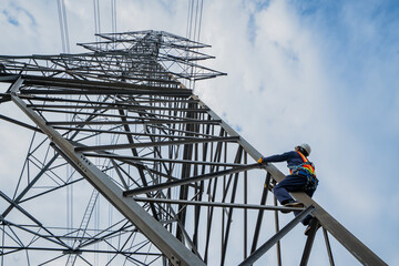 Asian electrical engineer wearing safety gear working high voltage pylon Engineering work on...