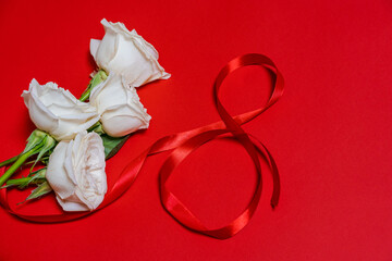 Greeting card for women's day March 8, number eight from red ribbons, bouquet of roses on a colored background