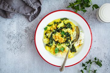 Vegan chickpea curry with rice and kale in plate, gray background. Alternative eco friendly food concept.