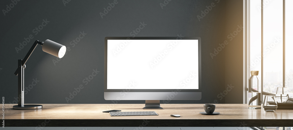 Aufkleber Blank white modern computer monitor with space for your web site or web design on wooden table with coffee cup, keyboard and lamp on dark wall background in sunlit room. 3D rendering, mock up