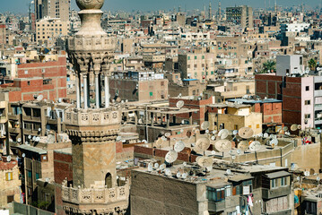 Islamic mosque minaret in front of crowded aerial cityscape view of Cairo, the densely populated...