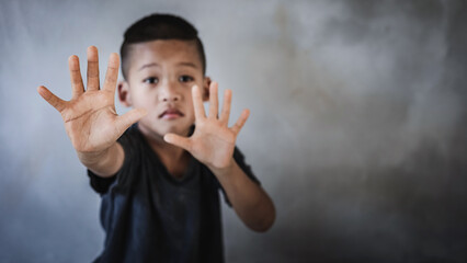 Kid boy showing hand signaling to stop useful to campaign against violence and pain. Stop abusing...