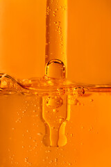 Vitamin C gel serum texture. Liquid gel or serum drop with pipette in orange color.