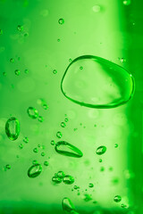 Aloe vera gel serum texture. Green cosmetic gel product with bubbles close up.