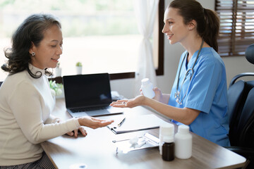 Portrait of a female doctor giving medicine to an elderly patient.