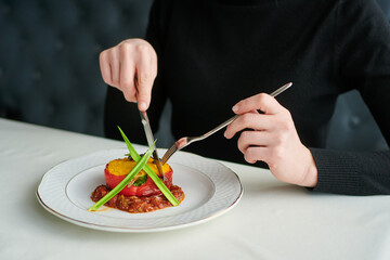 The dish is cut with a knife and fork in a restaurant