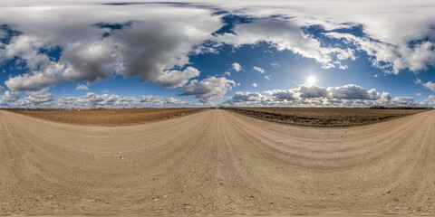 spherical 360 hdri panorama on gravel road with clouds on blue sky in equirectangular seamless projection, use as sky replacement in drone panoramas, game development as sky dome or VR content