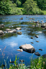 A sunny summer's day, with blue skies over River North Tyne at Chesters in Northumberland, UK