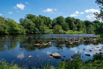 A sunny summer's day, with blue skies over River North Tyne at Chesters in Northumberland, UK